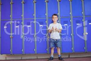 Portrait of smiling boy using mobile phone against lockers