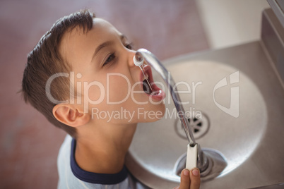 High angle view of boy drinking water from faucet