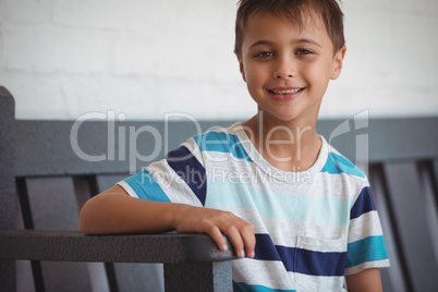 Portrait of smiling boy sitting on bench