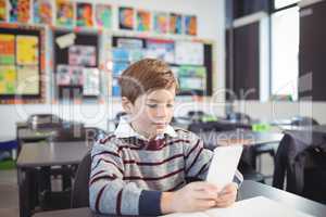 Boy using digital tablet in classroom
