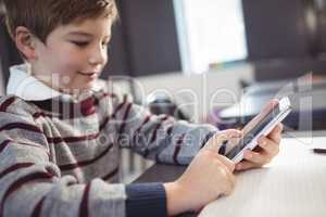 Close up of boy using mobile phone at desk