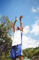 Low angle view of male teenager practicing basketball