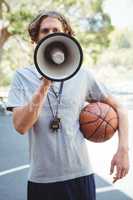 Male basketball coach using megaphone
