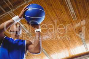Low angle view of male teenager with basketball