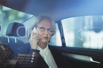 Businesswoman talking on phone in car