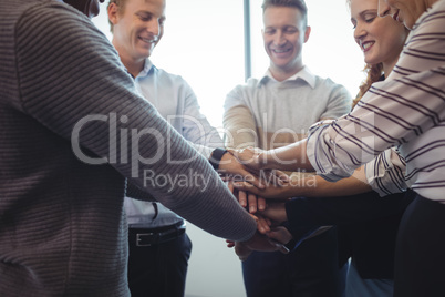 Happy business colleagues stacking hands