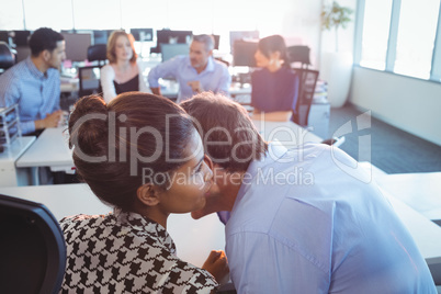 Business colleagues talking at desk in office