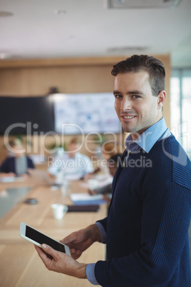 Portrait of smiling businessman using digital tablet