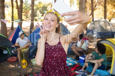 Happy woman gesturing while taking selfie