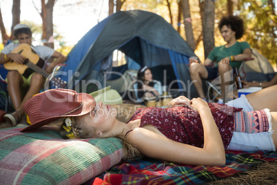 Young woman sleeping while friends sitting in background
