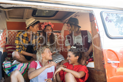 Cheerful friends sitting in camper van