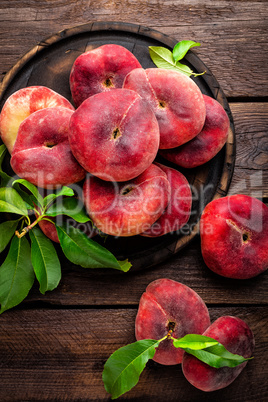 Peach, saturn or donut peaches with leaves