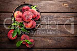 Peach, saturn or donut peaches with leaves