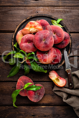 Peach, saturn or donut peaches with leaves