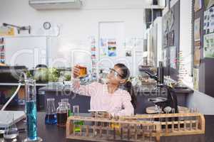 Elementary student examining liquid in beaker