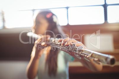 Girl practicing flute in classroom