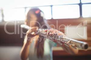 Girl practicing flute in classroom