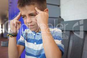 Boy suffering from headache while sitting on bench