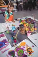 High angle view of elementary girl painting on paper