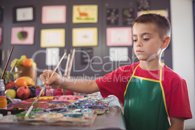 Boy painting at desk
