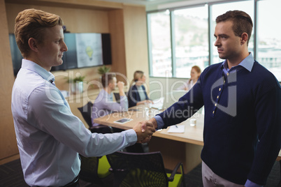 Business people shaking hands in board room