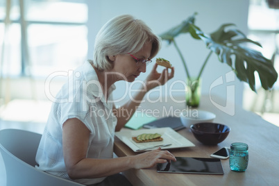 Businesswoman having food while working