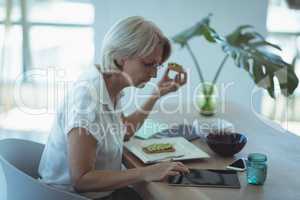 Businesswoman having food while working