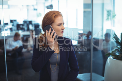 Young businesswoman looking away while taking on mobile phone