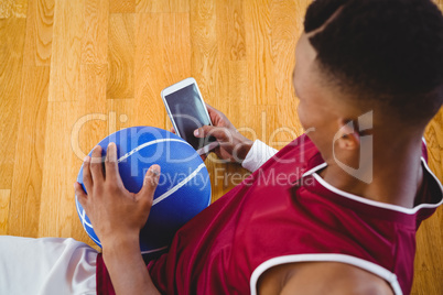 Overhead view of male basketball player using mobile phone