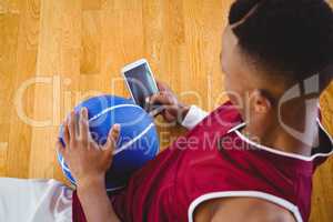Overhead view of male basketball player using mobile phone