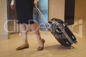Low section of businesswoman with luggage