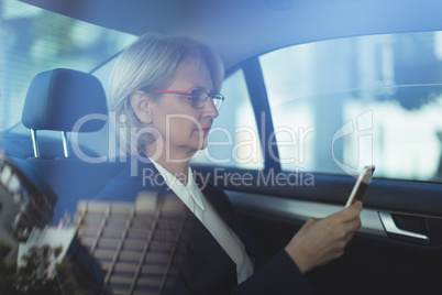 Businesswoman using phone in car