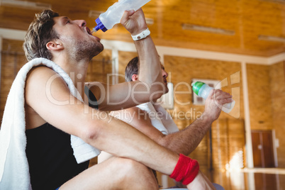 Male friends drinking water in court