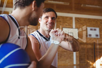 Smiling basketball players doing fist bump