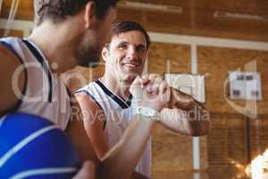 Smiling basketball players doing fist bump