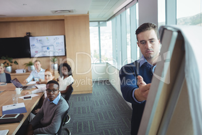Serious businessman explaining strategy to colleagues at office