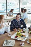 Young business colleagues talking at breakfast table