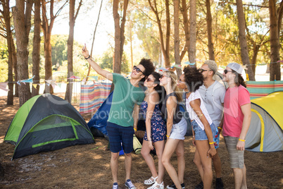 Smiling friends taking selfie at campsite