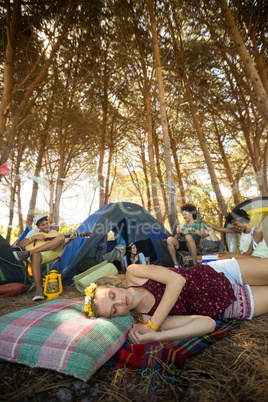 Young woman sleeping while friends enjoying in background