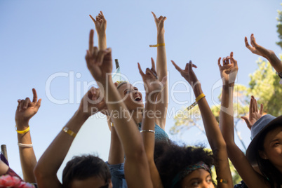 Cheerful woman with arms raised enjoying at music festival