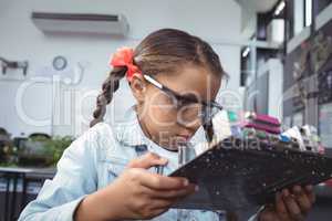 Concentrated elementary student examining circuit board
