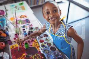 High angle portrait of elementary girl painting at desk