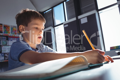 Boy writing on book