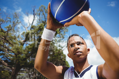 Close up of male teenager practicing basketball