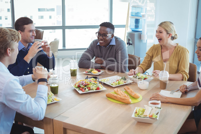 Happy business colleagues having lunch at office cafeteria