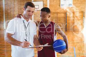 Coach discussing with basketball player