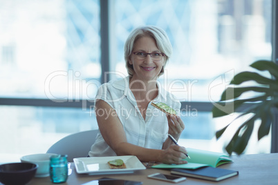 Portrait of businesswoman having food