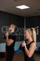 Friends exercising with kettle bells at gym