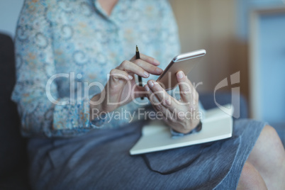 Midsection of businesswoman using phone