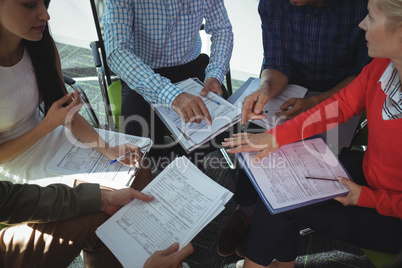 High angle view of business people sitting together with documents